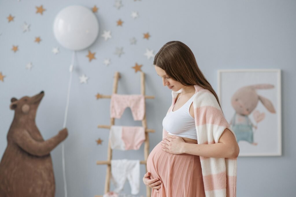 pexels-photo-7055944-7055944 Side view of expectant mother in a cozy nursery with soft pastel decor.